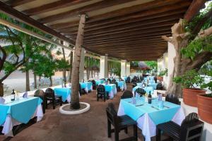 坎昆Grand Oasis Palm - All inclusive的一间拥有蓝色桌椅和树木的餐厅