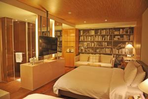 首尔格拉莫斯酒店的一间卧室配有床、电视和书籍