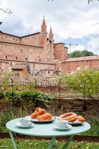 乌尔比诺Urbino Apartment - Torricini View的城堡顶上一张桌子,上面放着两盘食物