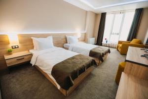 普列文Хотел Панорама的酒店客房,设有两张床和一张沙发