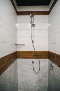 普列文Хотел Панорама的浴室内带软管的淋浴