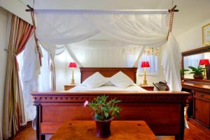 圣卢西亚圣露西亚湿地宾馆的一间卧室配有一张带桌子的天蓬床