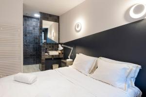 布鲁塞尔沃克旅馆的一间带白色大床的卧室和一间浴室
