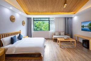 阳朔Qingshan Yuandai Resort Hotel Yangshuo Yulong River National Tourism Resort Store的一间卧室设有一张床和一间客厅。