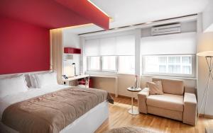 伊斯坦布尔努鲁子​​牙套房酒店的卧室设有红色的墙壁、一张床和一把椅子