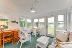 East QuogueBayfront East Quogue Retreat with Private Boat Dock的客厅配有桌子、椅子和窗户