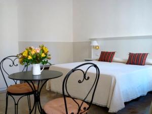 佛罗伦萨加拿大酒店的一间卧室配有一张床和一张鲜花桌子