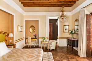 塞维利亚塞维利亚卡萨1800酒店的卧室配有一张床和一张桌子及椅子