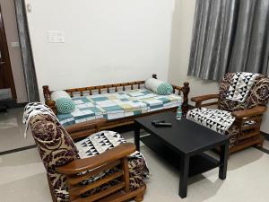 海得拉巴2 BHK Apartment Near AIG & ISB Gachibowli的客厅配有沙发和两把椅子