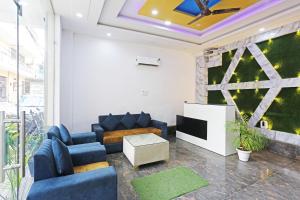 新德里Hotel Bella In Prime Near Delhi International Airport的客厅配有蓝色的沙发和电视