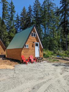 鲍威尔里弗Farmhouse cabin on 33 acre farm的小屋前方设有2把红色椅子