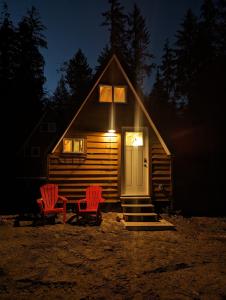 鲍威尔里弗Farmhouse cabin on 33 acre farm的小屋设有2把红色椅子和门