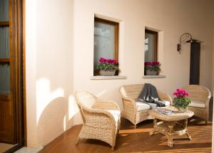博尔戈塞西亚La Burla的一个带藤椅和桌子的门廊以及两个窗户