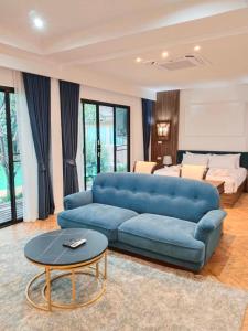 โรงแรม ดิ โอวาเล่ย์ [The O Valley Boutique Hotel]的客厅配有蓝色的沙发和桌子