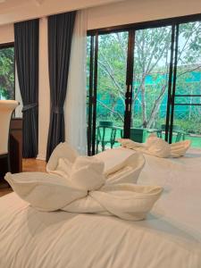 โรงแรม ดิ โอวาเล่ย์ [The O Valley Boutique Hotel]的卧室内的两张床和白色床单