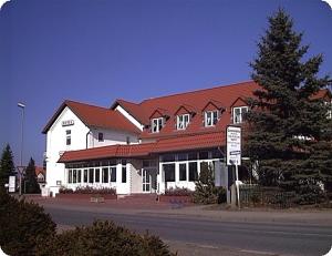 伯尔格伦德-雷特维施Hotel Kiebitz an der Ostsee的一座白色的大建筑,有红色的屋顶
