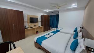 新德里Hotel Ramida Suites At Delhi Airport的一间卧室配有一张大床和电视