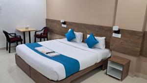 新德里Hotel Ramida Suites At Delhi Airport的一间卧室配有一张带蓝色枕头的大床