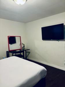 洛杉矶Centrally Located 2 Bed UCLA Apartment的卧室配有一张床,墙上配有电视