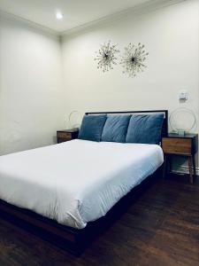 洛杉矶Centrally Located 2 Bed UCLA Apartment的一间卧室配有带白色床单和蓝色枕头的床。