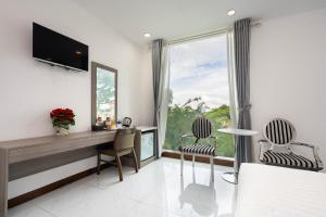 胡志明市Lam Kinh Hotel的一间卧室配有桌椅和窗户。