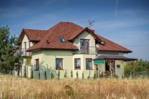Kotowice祖拉斯卡斯托洛卡农家乐的一座位于田野的红色屋顶的旧房子