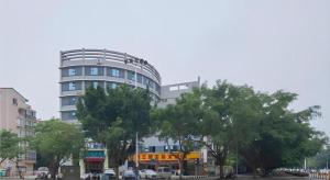 柳州City Comfort Inn Liuzhou Liunan Wanda RT-Mart的前面有树木的高楼