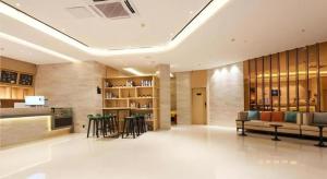 柳州City Comfort Inn Liuzhou Liunan Wanda RT-Mart的大楼内一个带沙发和椅子的大堂