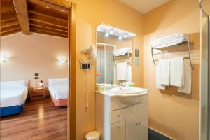拉林Hotel Alda Lalín的一间带水槽和镜子的浴室以及一张床