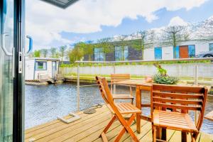 兹瓦茨勒伊斯stylish Houseboat 2 bedrooms near Giethoorn的一个带桌椅的庭院,享有水景