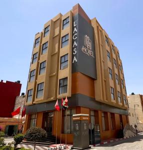 阿尤恩MH HOTEL LA CASA的前面有标志的建筑