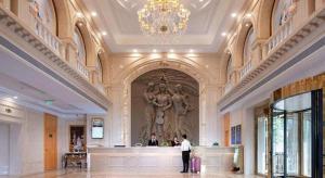 密云Venus Royal Hotel Beijing Miyun的站在一个配有雕像的大大厅里的人