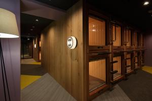 东京伯斯奈特咖啡厅及胶囊旅馆的走廊上设有木柜和墙上的标志