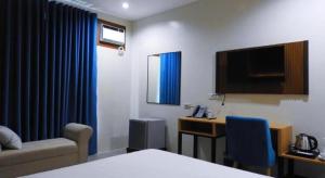 卡利博Vanyard Hotel的酒店客房配有一张床、一张书桌和一台电视。