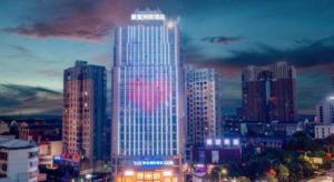 湘阴Kyriad Marvelous Hotel Xiangyin Bus Station的城市天际线,有一座有灯光的摩天大楼