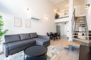 马德里loft reformado industrial con garaje的客厅配有沙发和桌子