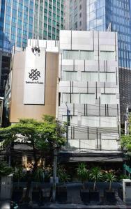 曼谷Sukhumvit Suites Hotel的一座高大的建筑,旁边有一个标志