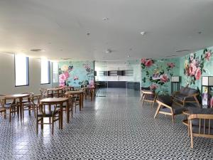 金兰市The Arena Cam Ranh Resort - Seaview的用餐室的墙壁上摆放着桌椅和鲜花