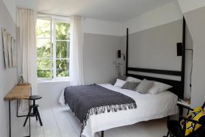 Neuilly-en-Thelle爱特里尔之家旅馆的白色的卧室设有一张大床和一个窗户
