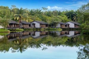 关丹Mangala Estate Boutique Resort - Small Luxury Hotels of the World的湖畔的一排小屋