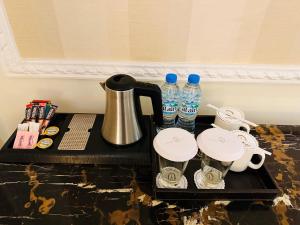 阿布扎比Royal Rose Abu Dhabi, a Curio Collection by Hilton Affiliated Hotel的一张桌子、咖啡壶和瓶装水