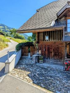 Erlenbach im SimmentalSwiss Mountain-Valley View Lodge的一座带门和石头车道的木屋