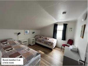 Grímsey博萨旅馆的一间带两张床的卧室和一间带窗户的房间