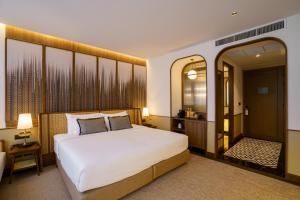 乌隆他尼Hotel MOCO的卧室配有一张白色大床和镜子