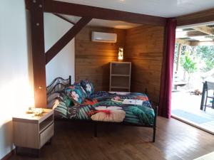 HaapuManta Lodge avec 4x4 Pleine nature的卧室配有一张床铺,位于带木墙的房间内