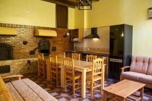 Hueva埃尔奥诺德波尔多乡村民宿的厨房以及带桌椅的用餐室。