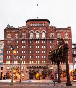 旧金山港苑酒店的一座大型砖砌建筑,前面有棕榈树