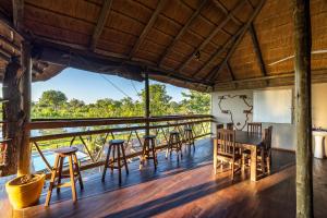 LesomaCHOBE MOPANI FOREST LODGE & CAMP SITE的甲板上配有桌椅的房间