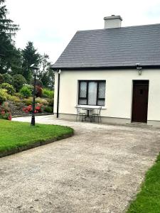 FarnaghtFarnaught Farmhouse Apartment, Lough Rynn, Mohill的前面有一张野餐桌的白色建筑