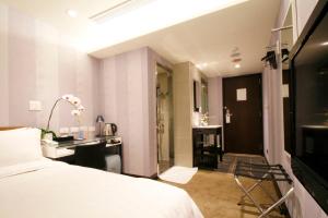 台北璞涟商旅的一间带一张床和一张书桌的卧室以及一间浴室。